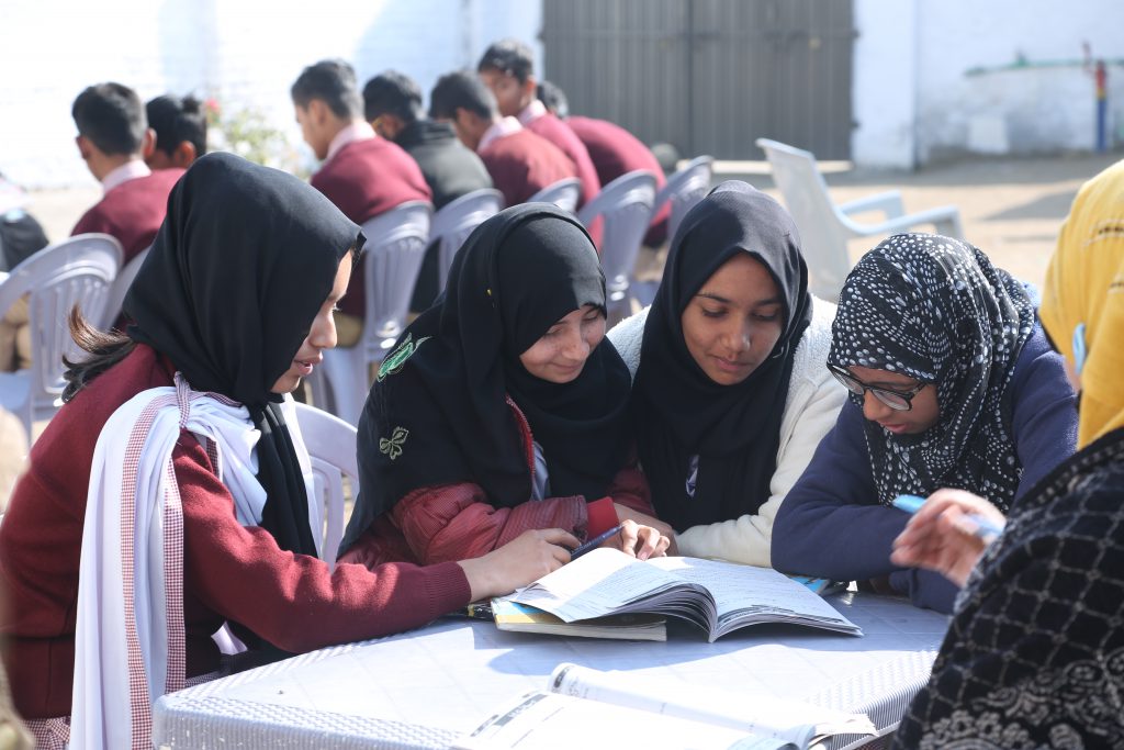 Girls studying outside at Allama Iqbal School Dina.